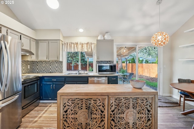 kitchen featuring blue cabinets, sink, tasteful backsplash, hanging light fixtures, and appliances with stainless steel finishes