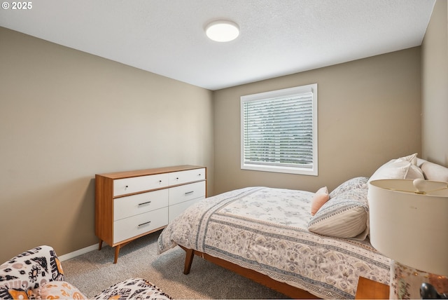 bedroom with light colored carpet and a textured ceiling