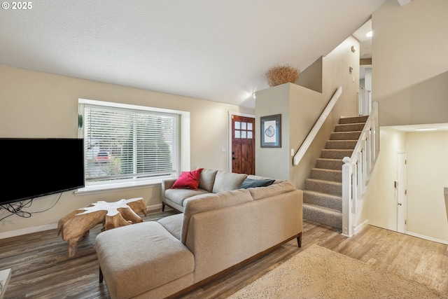 living room with wood-type flooring, vaulted ceiling, and a healthy amount of sunlight