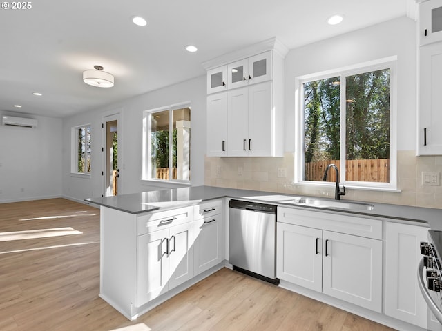 kitchen featuring appliances with stainless steel finishes, a sink, plenty of natural light, a wall unit AC, and recessed lighting