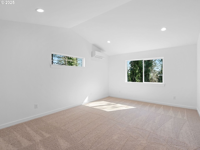 carpeted empty room featuring plenty of natural light, a wall unit AC, vaulted ceiling, recessed lighting, and baseboards