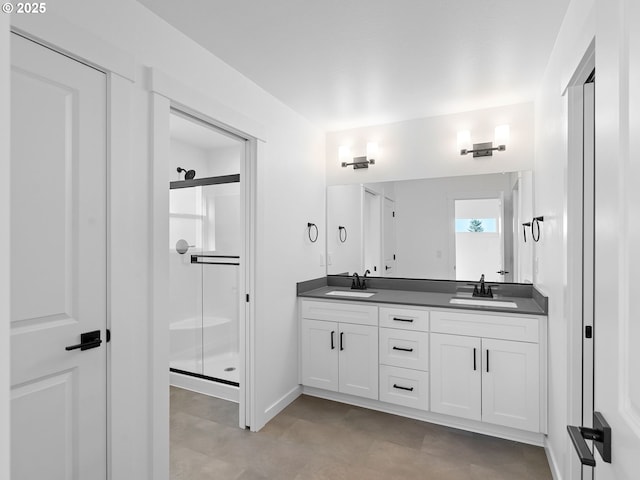 full bathroom featuring a shower stall, double vanity, and baseboards