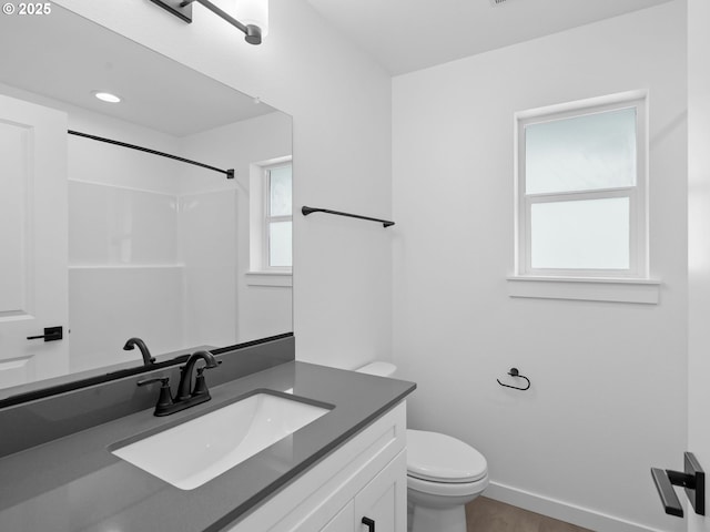 full bathroom featuring toilet, vanity, and baseboards