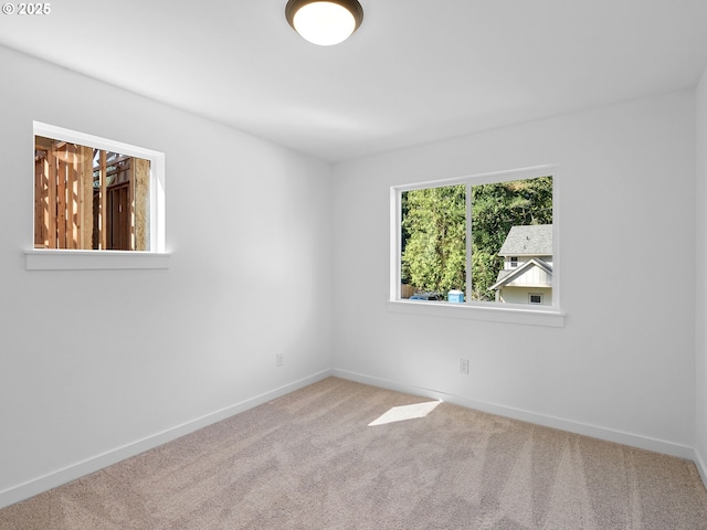 carpeted empty room with baseboards