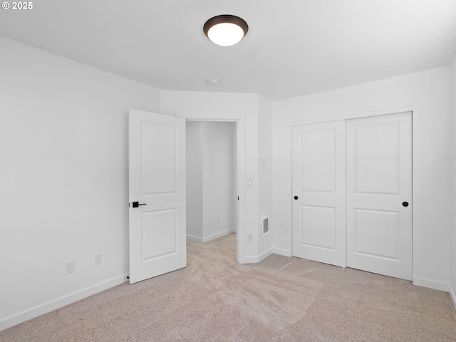unfurnished bedroom with carpet, baseboards, and a closet