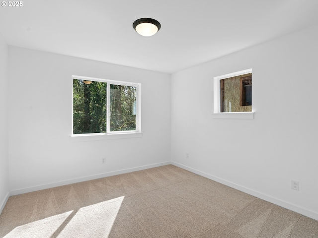 carpeted empty room with baseboards