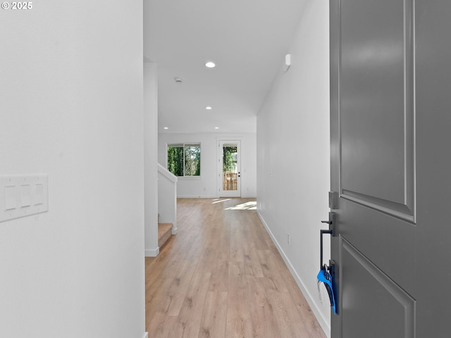 corridor with light wood-style flooring, recessed lighting, baseboards, and stairway