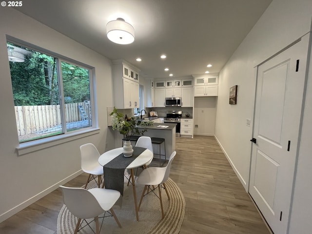 dining area with baseboards, recessed lighting, and light wood-style flooring
