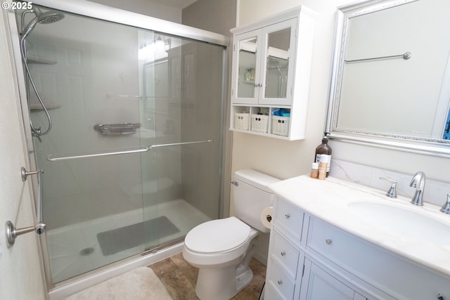 bathroom featuring vanity, toilet, and walk in shower