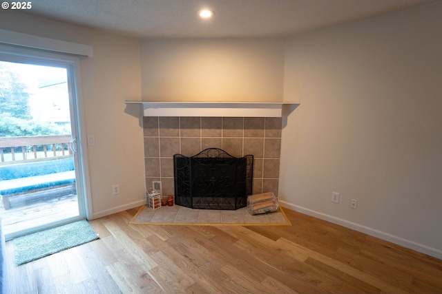 interior details featuring a tiled fireplace and hardwood / wood-style floors