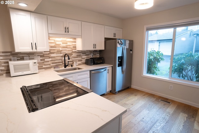 kitchen with sink, stainless steel appliances, and white cabinets