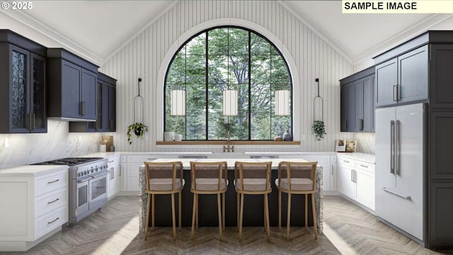 kitchen with high end appliances, a center island, light parquet flooring, and white cabinets