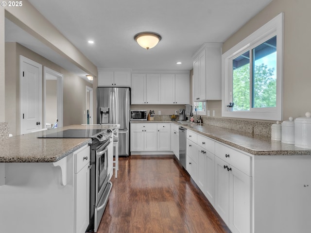 426 NE Hill St, Sheridan, OR 97378 - kitchen featuring stainless steel appliances, a sink, dark wood-style flooring, white cabinetry, and light stone countertops