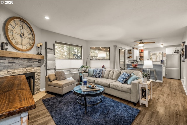 living room with a fireplace, hardwood / wood-style floors, and ceiling fan