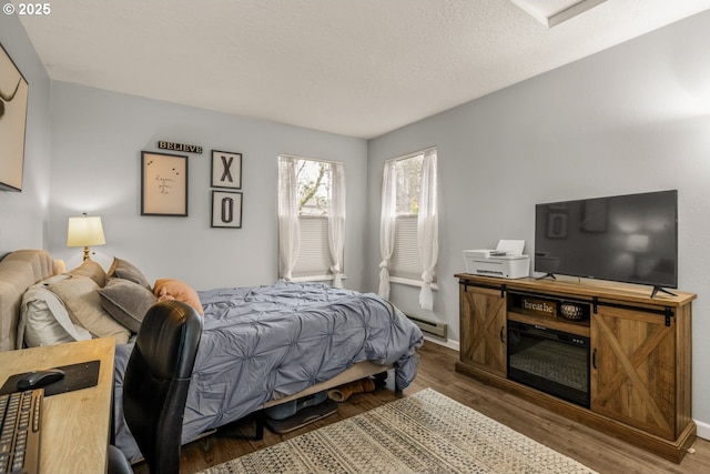 bedroom featuring wood-type flooring and a textured ceiling