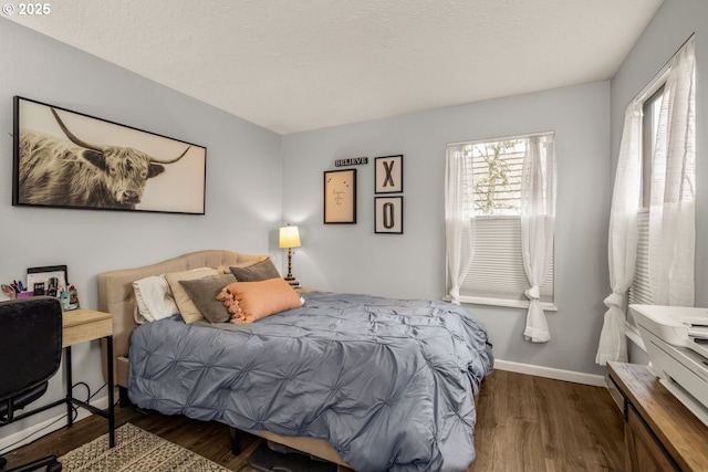 bedroom featuring dark hardwood / wood-style flooring and a textured ceiling