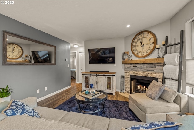 living room featuring a stone fireplace and hardwood / wood-style floors