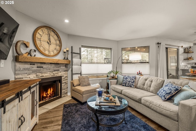 living room featuring hardwood / wood-style flooring and a stone fireplace