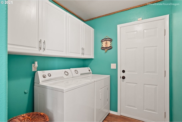 laundry room featuring washer and clothes dryer, light hardwood / wood-style floors, and cabinets