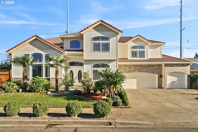 mediterranean / spanish-style home featuring a garage and a front yard