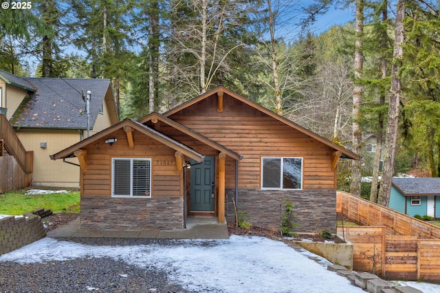 view of front of house with stone siding and fence