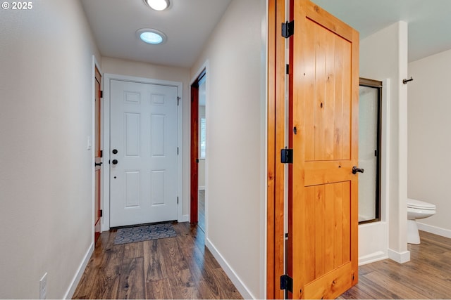 hallway featuring dark wood finished floors and baseboards