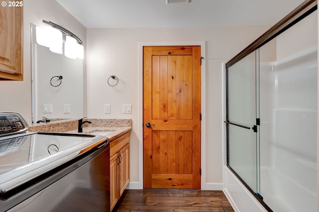 bathroom featuring enclosed tub / shower combo, visible vents, wood finished floors, and vanity