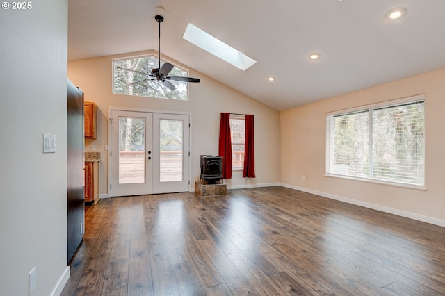 unfurnished living room featuring lofted ceiling with skylight, baseboards, dark wood-style flooring, and french doors