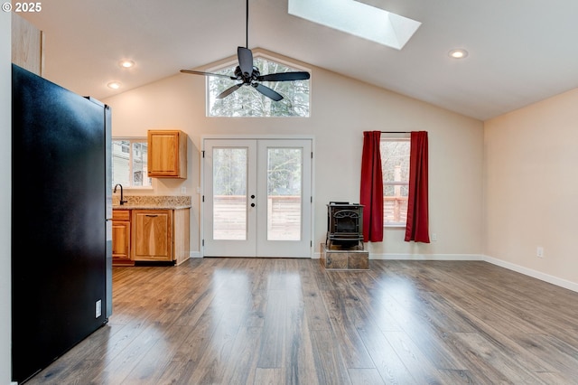 interior space featuring freestanding refrigerator, a healthy amount of sunlight, light countertops, and wood finished floors