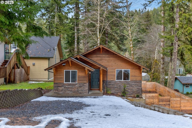 view of front facade featuring stone siding and fence