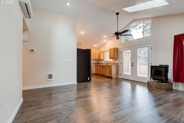 unfurnished living room with visible vents, dark wood finished floors, french doors, a sink, and a wall mounted AC