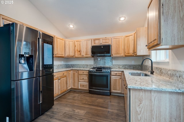 kitchen featuring lofted ceiling, dark wood-style floors, appliances with stainless steel finishes, light brown cabinets, and a sink