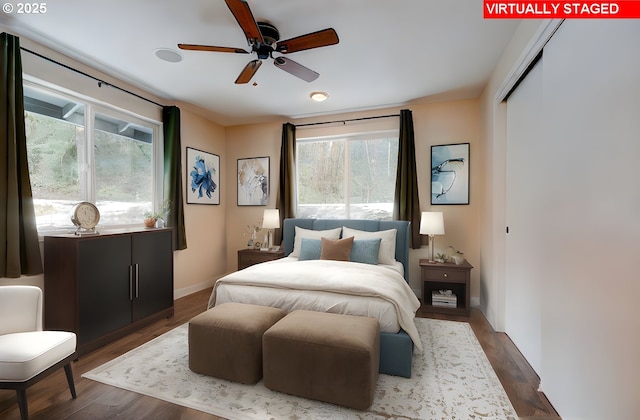 bedroom featuring baseboards, dark wood finished floors, and a closet