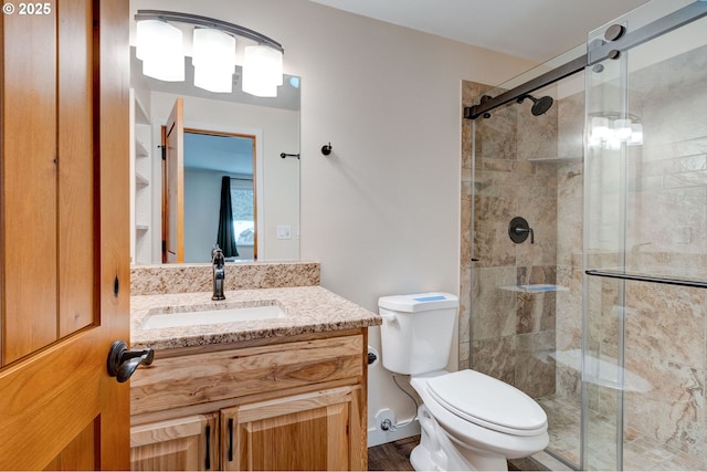 full bathroom featuring toilet, a shower stall, and vanity