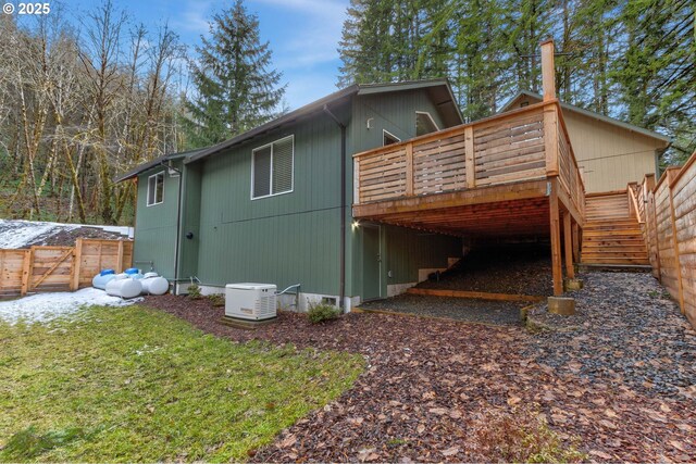 exterior space featuring stairs, fence, and a wooden deck