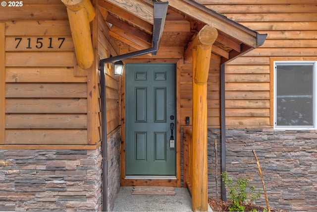 doorway to property featuring stone siding