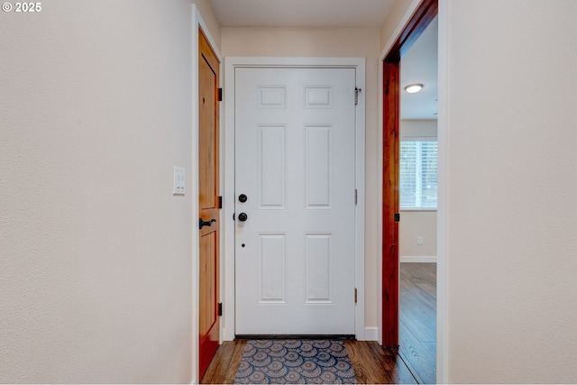 doorway to outside with dark wood-style flooring and baseboards