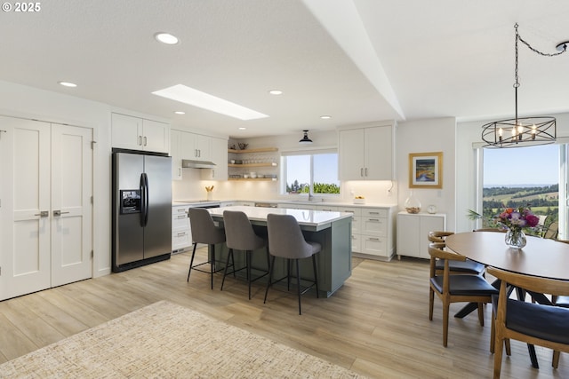 17385 NE Fairview Dr, Dundee, OR 97115 - kitchen featuring stainless steel fridge with ice dispenser, a sink, a kitchen breakfast bar, light countertops, and a kitchen island