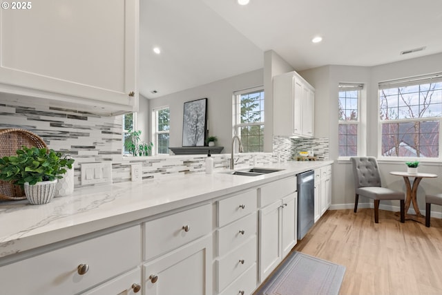 kitchen featuring stainless steel dishwasher, visible vents, plenty of natural light, and a sink