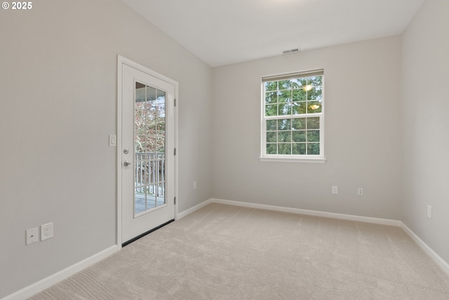 carpeted empty room featuring baseboards and visible vents