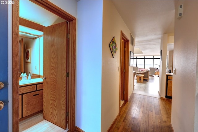 hall featuring visible vents and hardwood / wood-style flooring