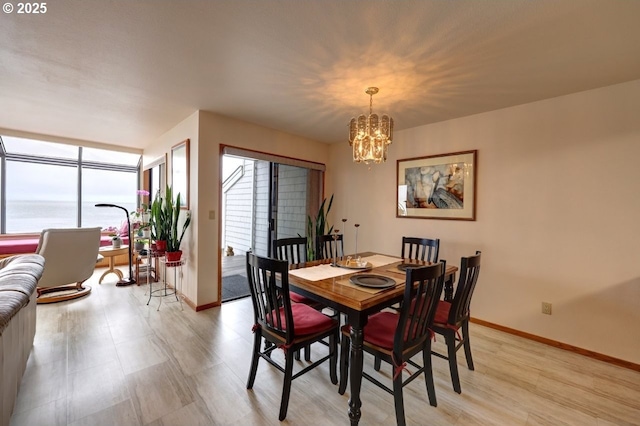 dining area featuring a chandelier and baseboards