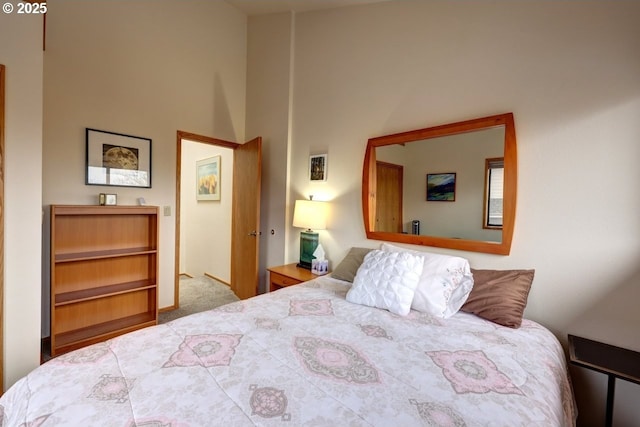 carpeted bedroom with a high ceiling