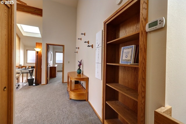 hallway featuring carpet floors and a skylight