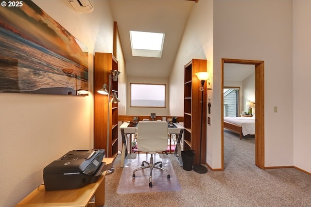 carpeted office featuring vaulted ceiling with skylight and baseboards