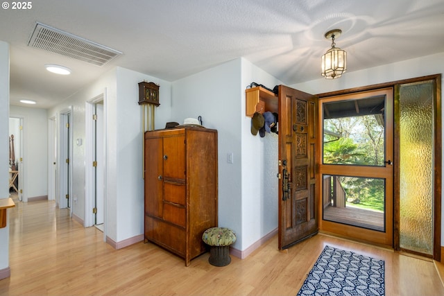 entrance foyer featuring visible vents, baseboards, and light wood-style floors