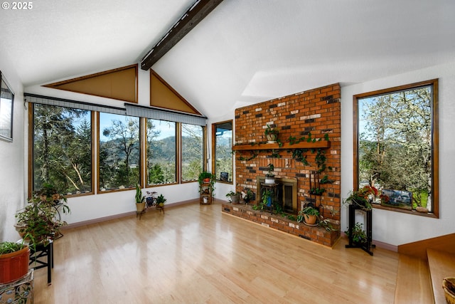 living area featuring baseboards, wood finished floors, and vaulted ceiling with beams