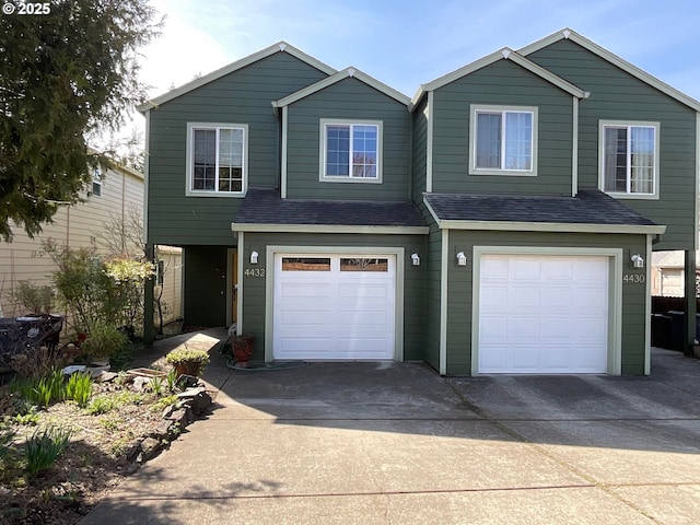 view of front of house featuring a garage, driveway, and a shingled roof