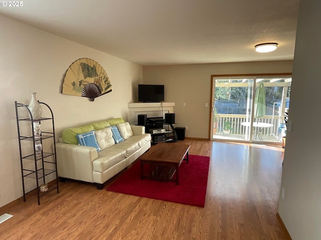 living area featuring baseboards and wood finished floors