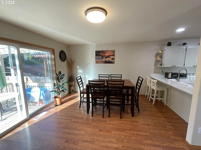 dining space with wood finished floors, baseboards, and recessed lighting